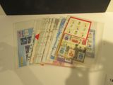 a lot of stamps on a table with a person holding a cell phone