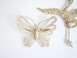 a butterfly brooch and a bird brooch on a table