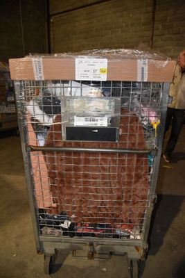 a cage with a television on top of it in a warehouse