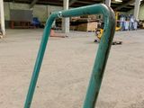 a green hand truck in the middle of a large warehouse