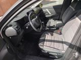 the interior of a car with the door open and the driver ' s seat down
