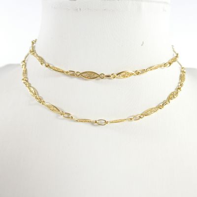 un gros plan sur un mannequin portant un collier à chaîne en or