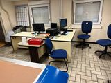 une pièce équipée d'un bureau, de chaises et d'un ordinateur posé dessus