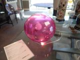 une table en verre sur laquelle se trouve une balle rose