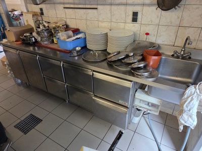 une cuisine avec beaucoup de vaisselle sale sur le plan de travail