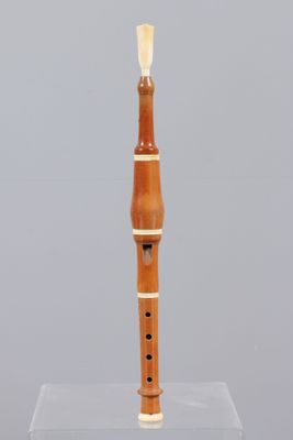 a wooden flute on display on a clear stand