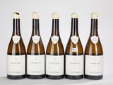 six bouteilles de vin sont alignées sur une table