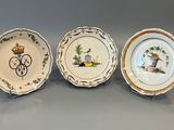 trois assiettes en porcelaine ornées de motifs, posées sur une table