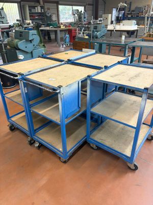 a group of four blue metal tables sitting on top of a hard wood floor