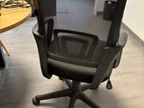an office chair with a computer on top of it in front of a desk