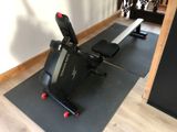 a black and red exercise bike on a mat in a room