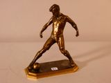 figurine en bronze représentant un homme en train de frapper un ballon de football, posée sur un socle en bois