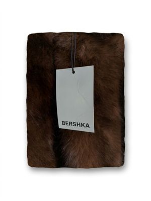 un gros plan sur un coussin en fourrure marron muni d'une étiquette