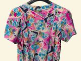 pink and blue floral top on a hanger against a white background