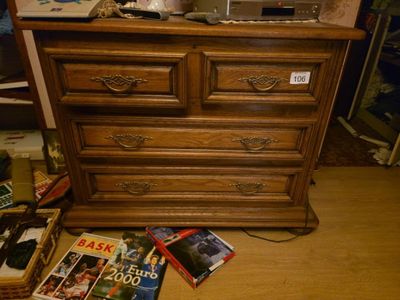 une commode en bois avec des magazines posés par terre à côté