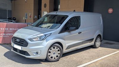 une camionnette argentée garée devant un immeuble