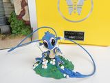 a figurine of a blue and white cat on a green leaf