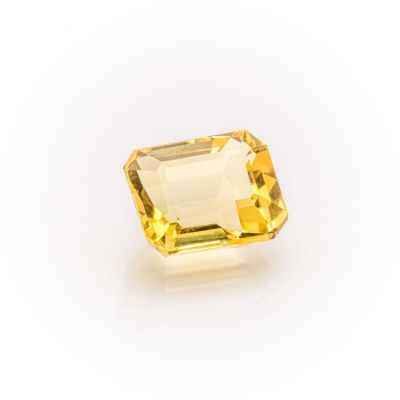 a yellow sapphire stone on a white background