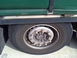 a green truck that has a flat tire on it