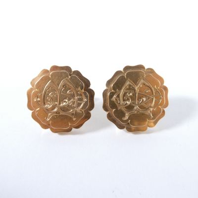 une paire de boucles d'oreilles vintage en forme de fleurs, de couleur dorée, sur fond blanc