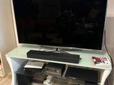 a flat screen tv sitting on top of a glass stand