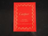 a red book with gold writing on it on a black surface