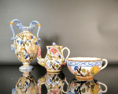 three vases and a cup on a table