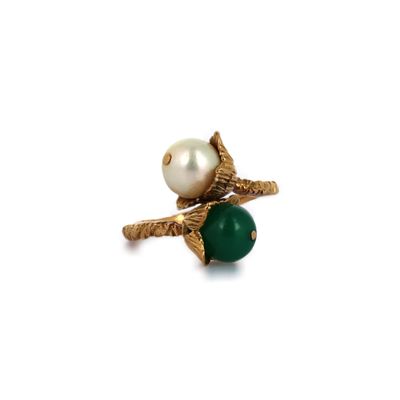 un gros plan d'une bague ornée d'une perle et d'une pierre verte