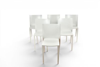 several white chairs are arranged in a circle on a white surface