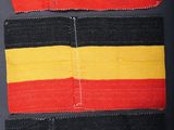 a close up of a piece of cloth with a red, yellow and black stripe