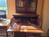 a desk with a book case and a computer on it