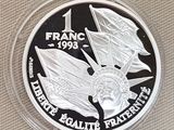 un gros plan d'une pièce d'argent sur laquelle figure un drapeau