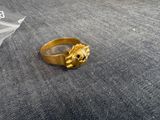 un gros plan d'une bague en or ornée d'une tête de lion