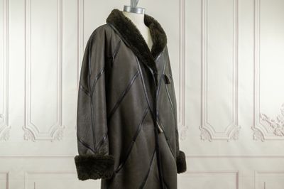 a black coat with a fur collar on a mannequin