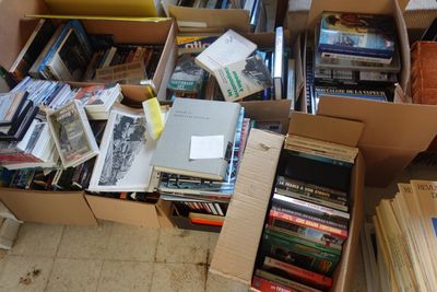 de nombreuses caisses de livres posées à même le sol de cette pièce