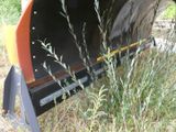 a tractor plow that is sitting in the grass
