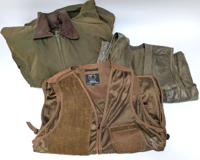 deux vestes et un gilet sont posés sur une surface blanche