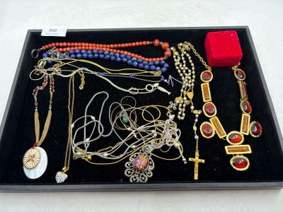 un plateau noir sur lequel sont disposés divers colliers et bracelets