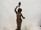 une statue de femme tenant une fleur à la main