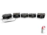 four cameras sitting next to each other on a white surface