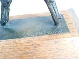 a statue of a horse that is standing on a wooden base