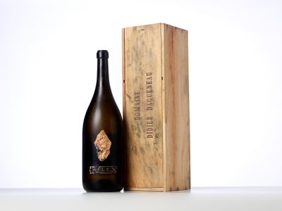 the bottle of wine is next to a wooden box on the table