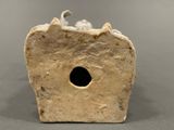 a small stone object with a cat on it