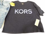black t - shirt with the word kors printed on it next to a pair of jeans
