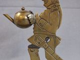 brass figurine of a man holding a pot and a kettle