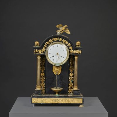 a black and gold clock with a bird on top of it