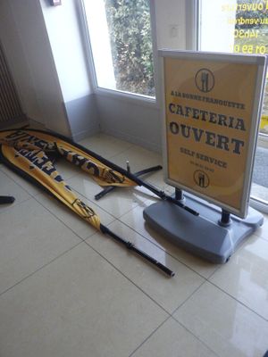 une pancarte indiquant « Cafferia Ouvertt » posée à côté d'une paire de skis posée par terre