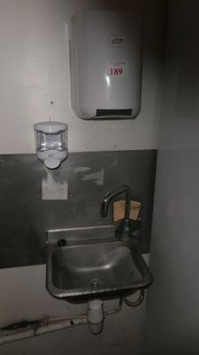 un lavabo et un distributeur de savon dans une petite salle de bains