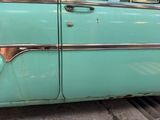 a man sitting in the driver ' s seat of an old car
