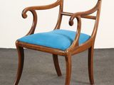 une chaise en bois sur laquelle est posé un coussin bleu